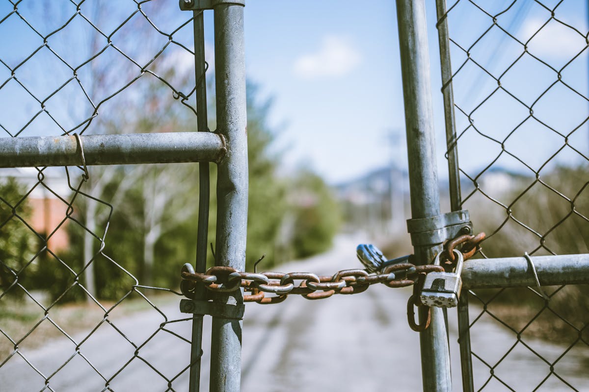 Close-up of a padlocked chain link fence showing the cheapest real fencing option